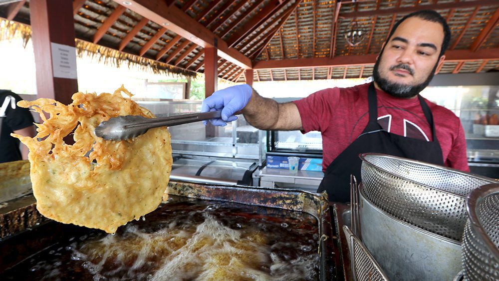 A cook deep-frying bacalaito, one of the most popular Puerto Rican foods in Puerto Rico