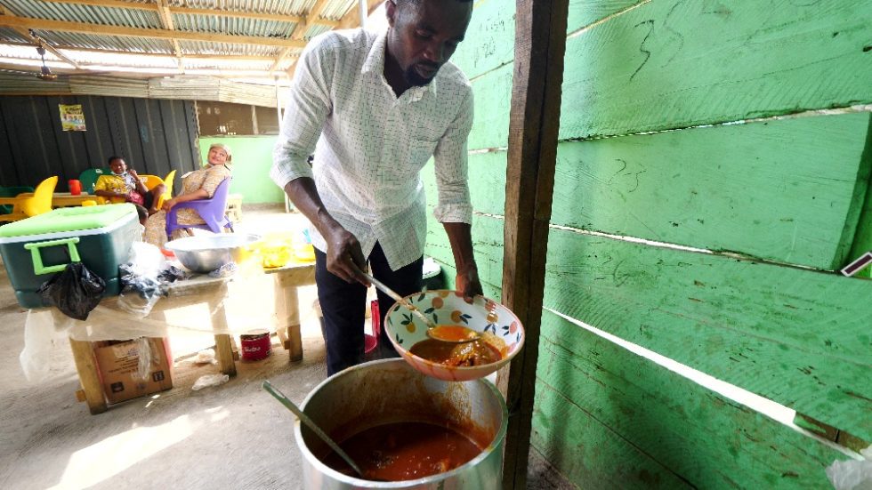 Man serving West African food