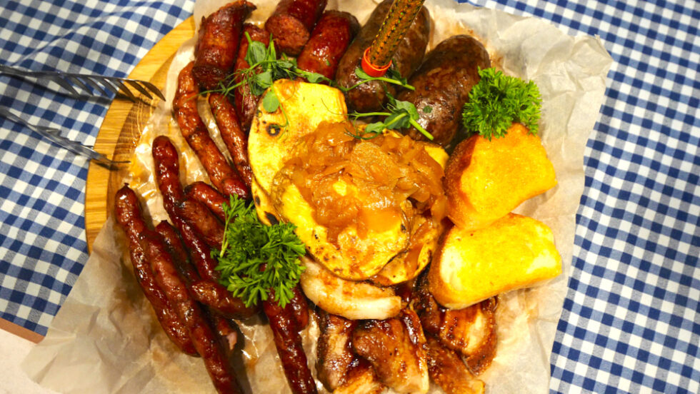 Transcarpathian sausages, bacon, baked potatoes, and onions at Poryadniy Gazda Restaurant in Mukachevo, Ukraine