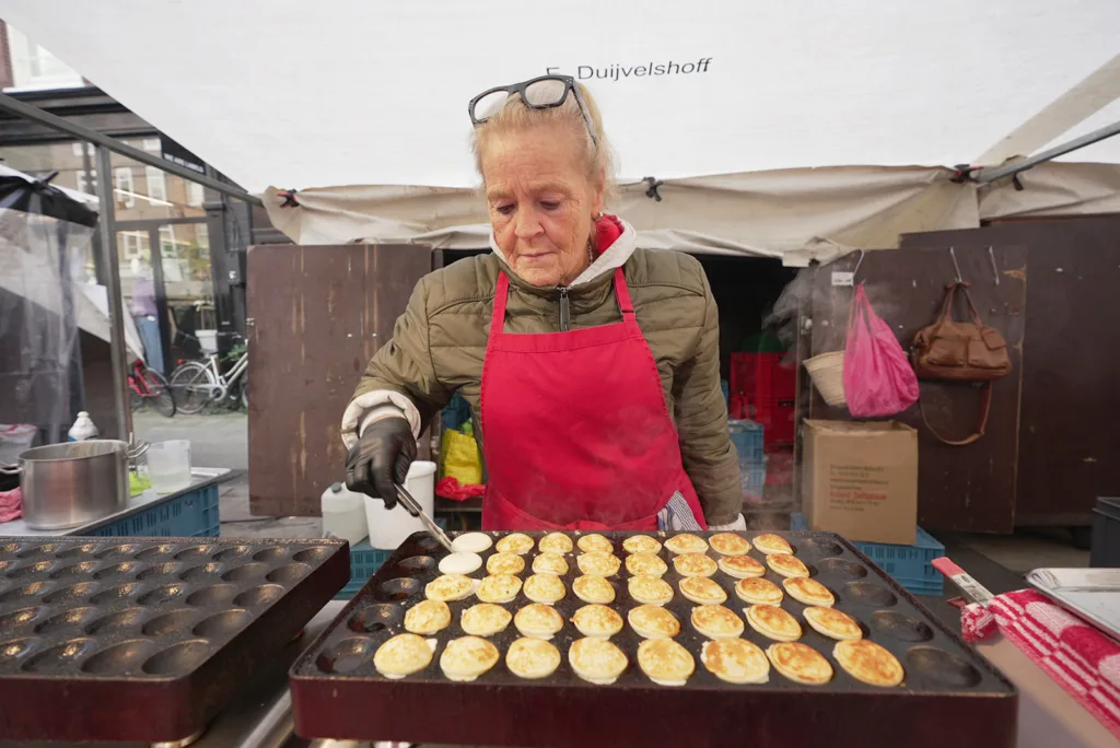 A food vendor in Amsterdam prepares tiny pancakes | Davidsbeenhere