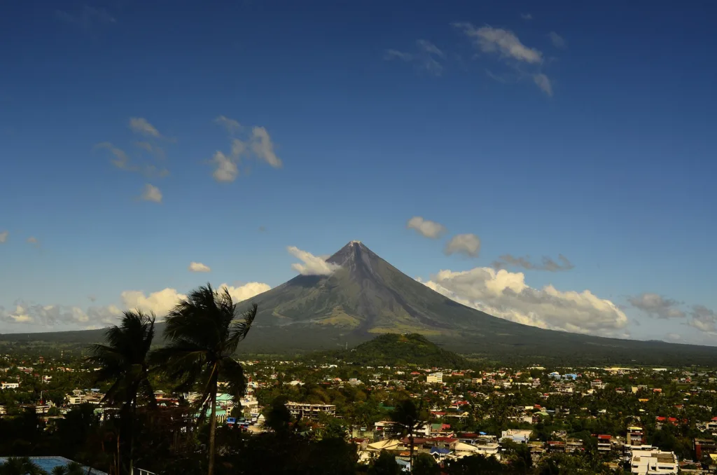 A large volcano rises above a town in the Philippines | Davidsbeenhere