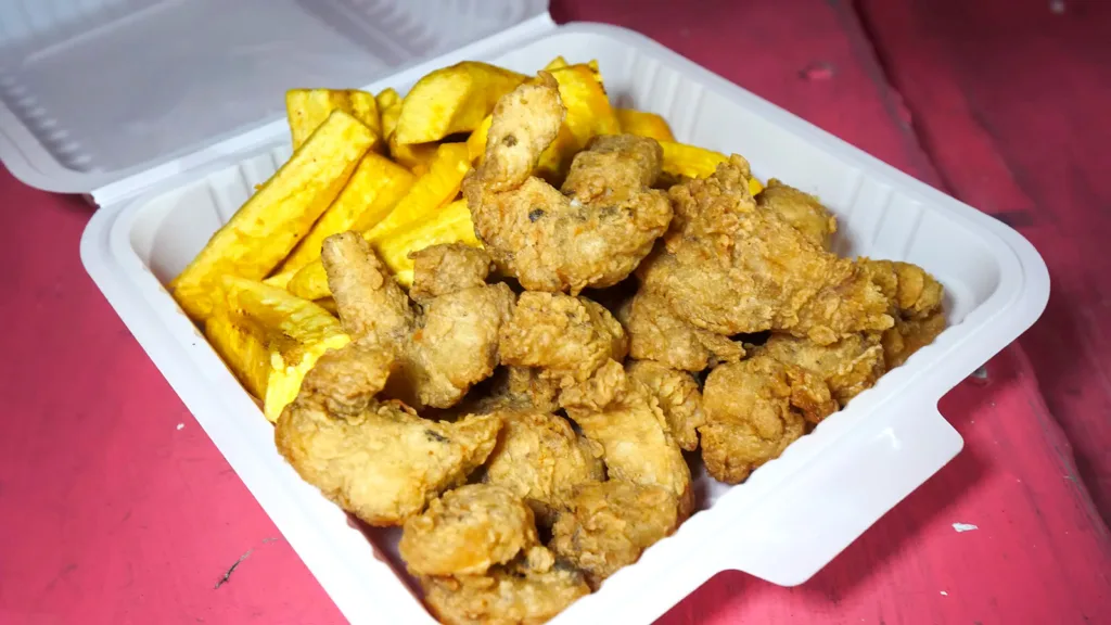 A styrofoam container filled with fried fish nuggets and fried plantain fries | Davidsbeenhere