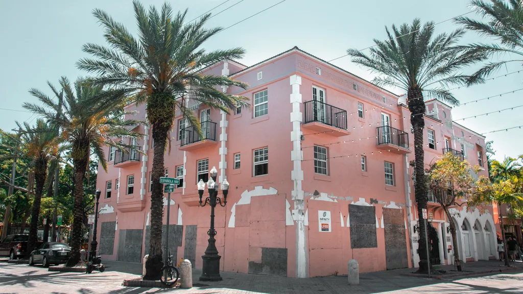 A pink building on a street lined by palm trees in Miami, Florida | Davidsbeenhere