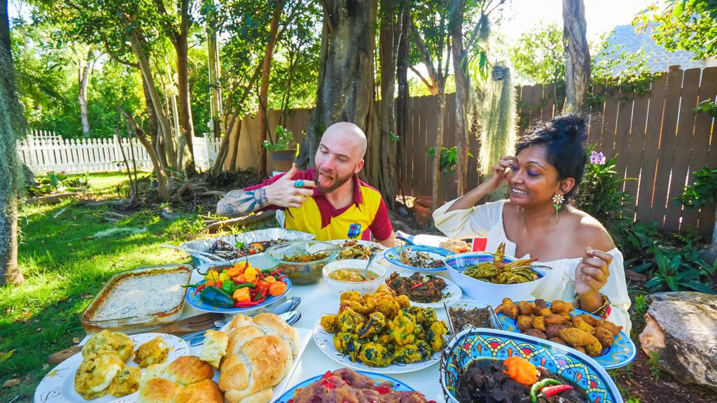 David Hoffmann and Sandy Roberts sitting around a table full of Guyanese food dishes | Davidsbeenhere