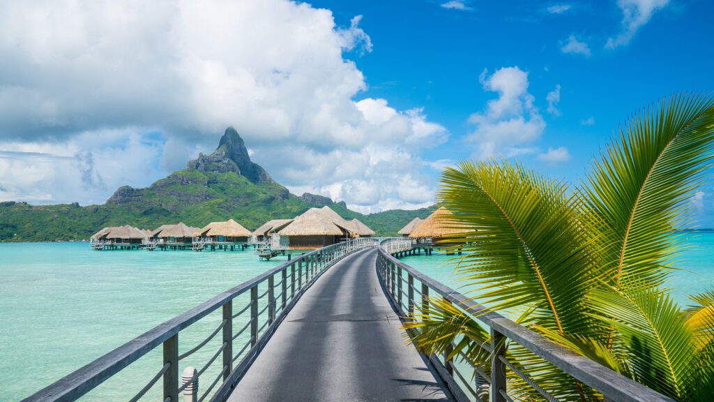 An overwater path leading to a group of bungalows | Davidsbeenhere